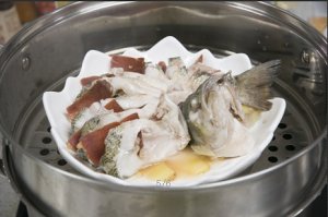 將鱸魚成花狀擺好，將火腿切片放入各縫隙中，放入鍋中隔水蒸12分鐘拿出，撒上蔥花即可。