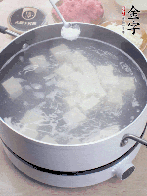 豆腐切成大小均勻正方體，鍋內(nèi)放水，加一點鹽焯水10秒。
